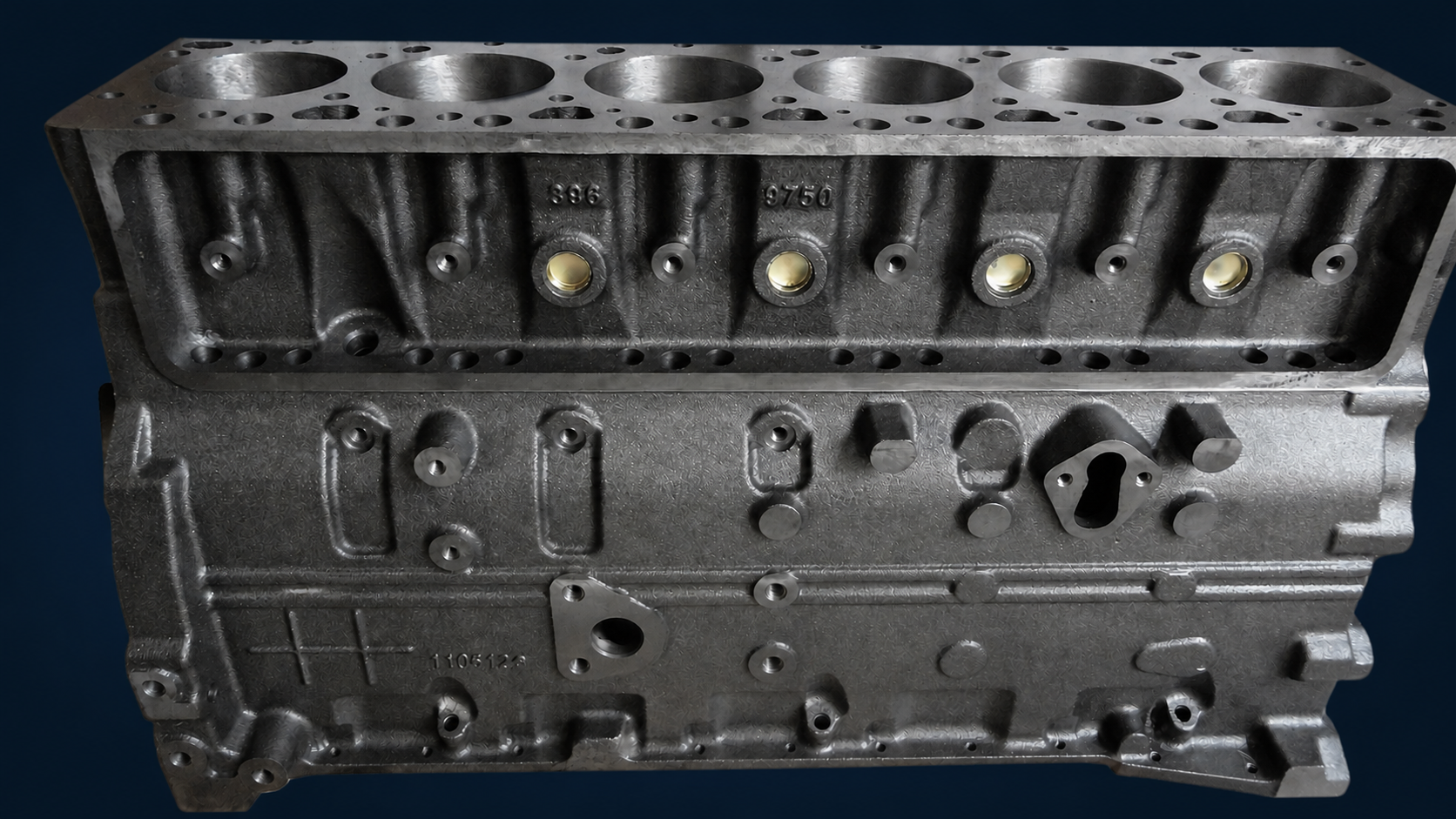 Machined inline-six cylinder block on a deep navy background